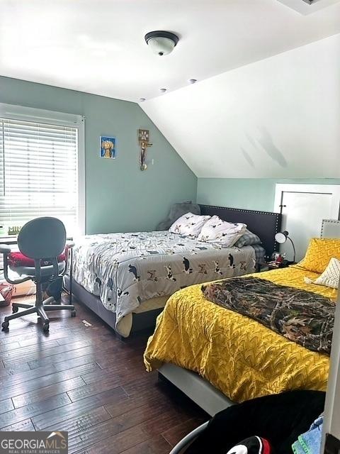 bedroom featuring vaulted ceiling and dark wood-type flooring