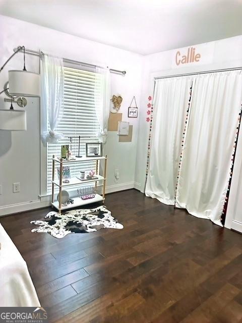 bedroom with dark wood-type flooring