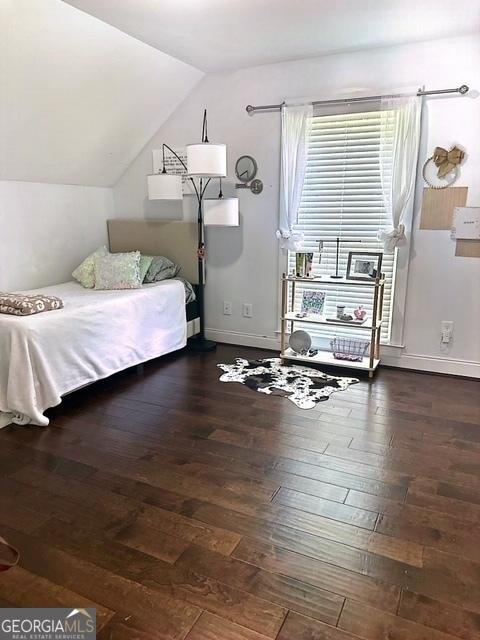 bedroom with dark wood-type flooring and vaulted ceiling