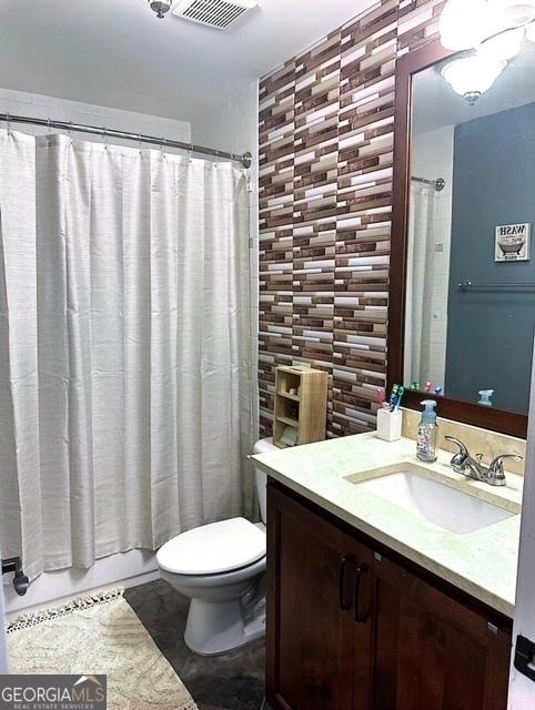 full bathroom featuring vanity, shower / tub combo, and toilet