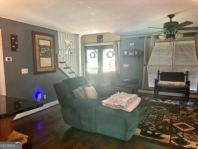 living room with ceiling fan, dark hardwood / wood-style flooring, and french doors