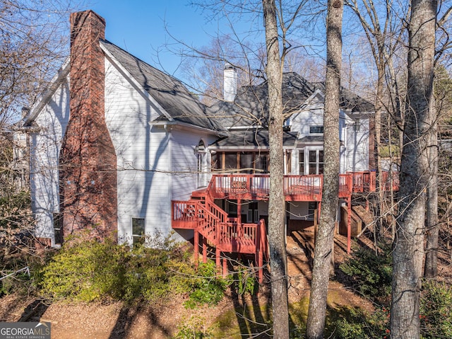 back of house with a sunroom and a deck