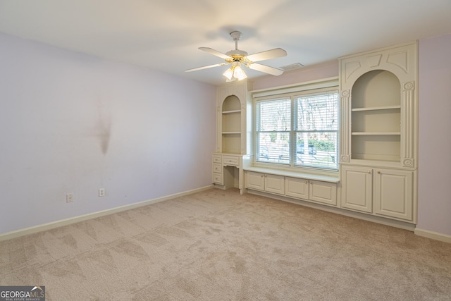 carpeted empty room with built in features and ceiling fan