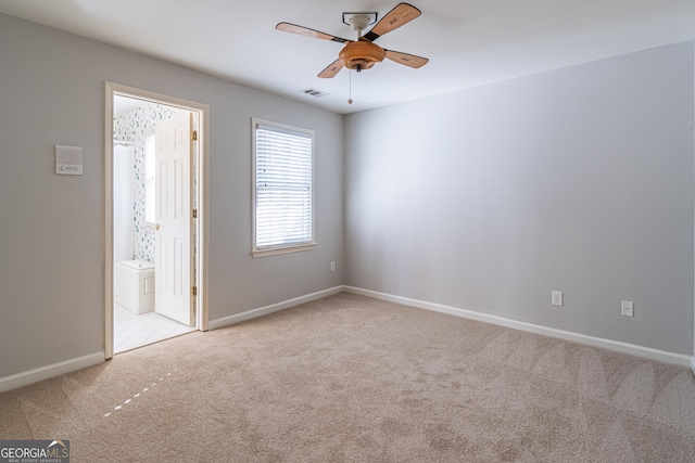 spare room featuring light colored carpet and ceiling fan