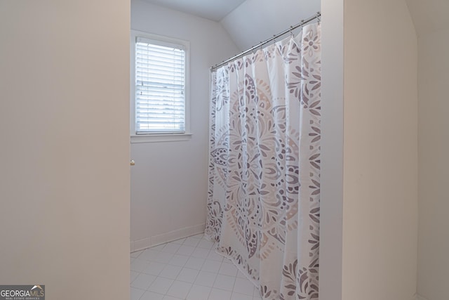 bathroom featuring lofted ceiling, a shower with curtain, and tile patterned floors