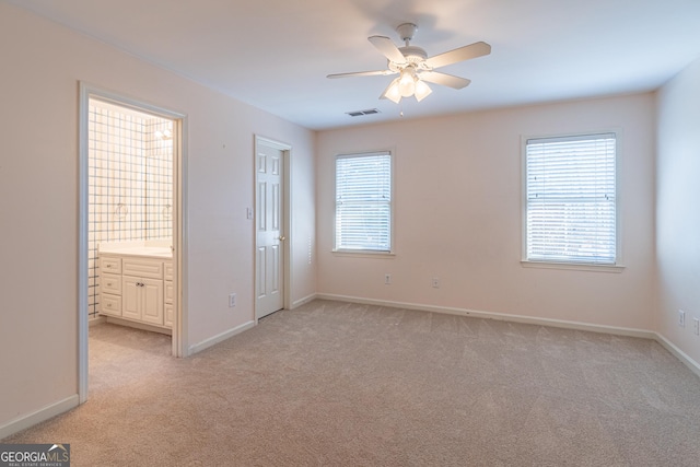 unfurnished bedroom with light colored carpet and ensuite bathroom