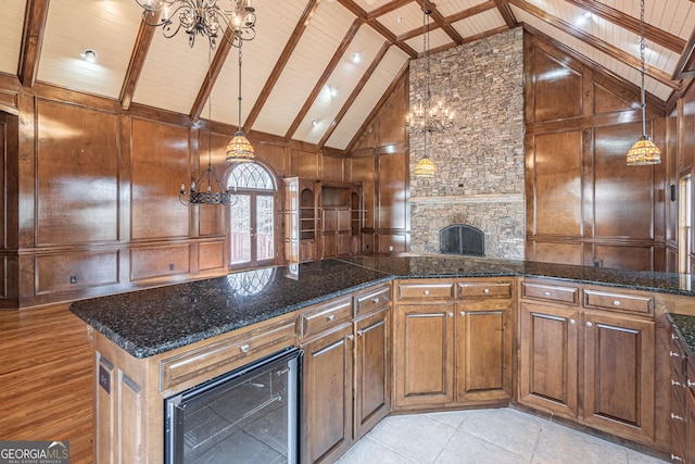 kitchen featuring wine cooler, wood walls, wood ceiling, an inviting chandelier, and pendant lighting