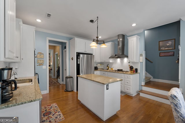 kitchen with white cabinetry, wall chimney range hood, and appliances with stainless steel finishes