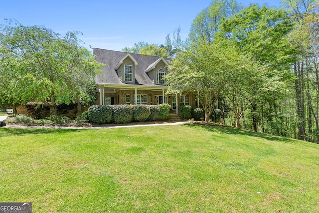 cape cod-style house featuring a front yard and covered porch