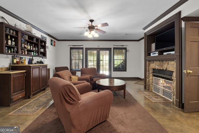 living room featuring french doors, a stone fireplace, crown molding, indoor bar, and ceiling fan