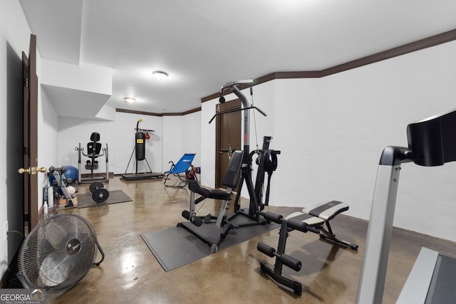 workout room featuring crown molding