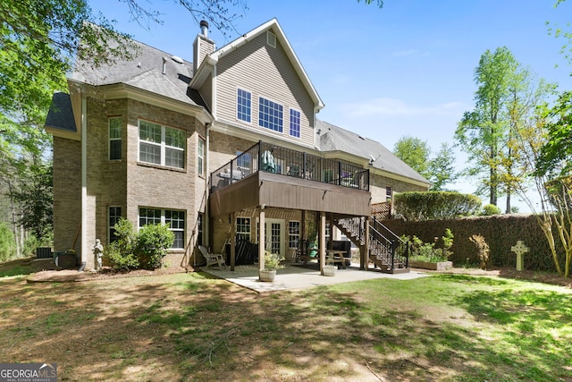 rear view of house with a patio area, a lawn, and a deck