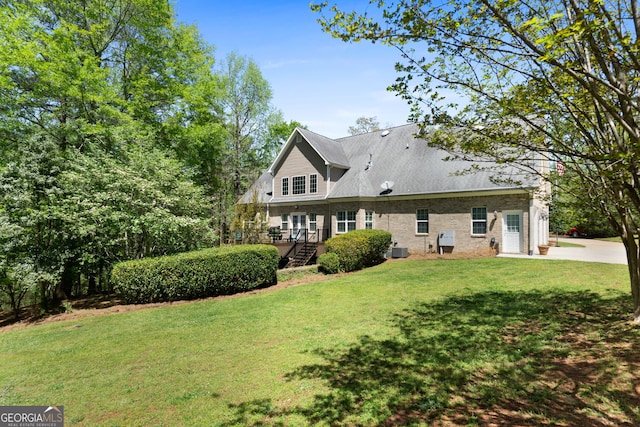 back of property with a yard and central air condition unit