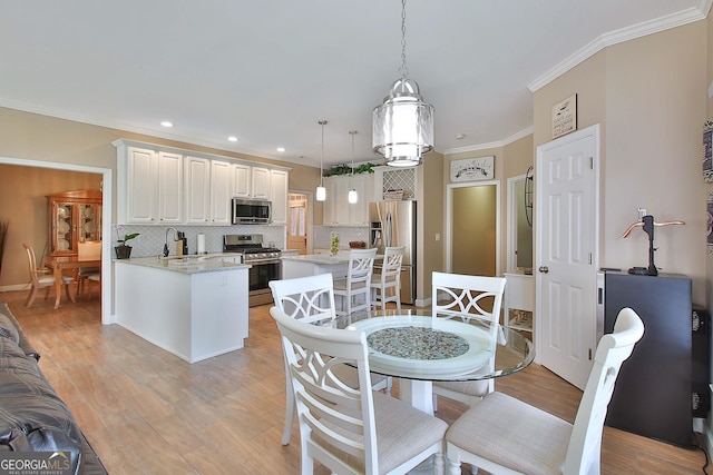 dining room featuring crown molding, light hardwood / wood-style floors, and sink