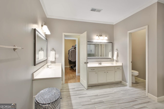 bathroom with crown molding, wood-type flooring, vanity, and toilet