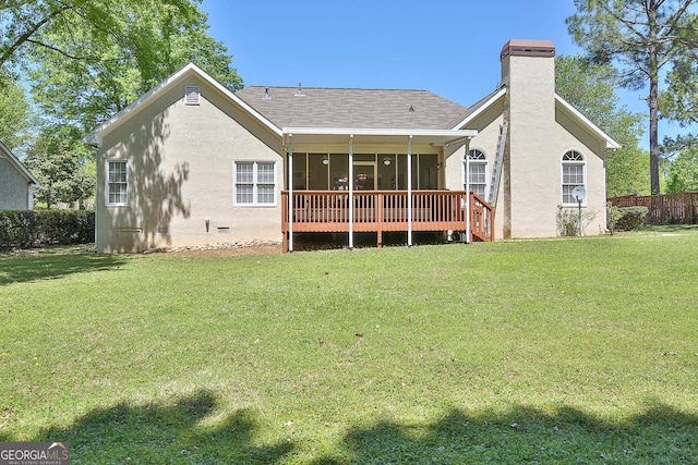 rear view of property featuring a wooden deck, a sunroom, and a lawn