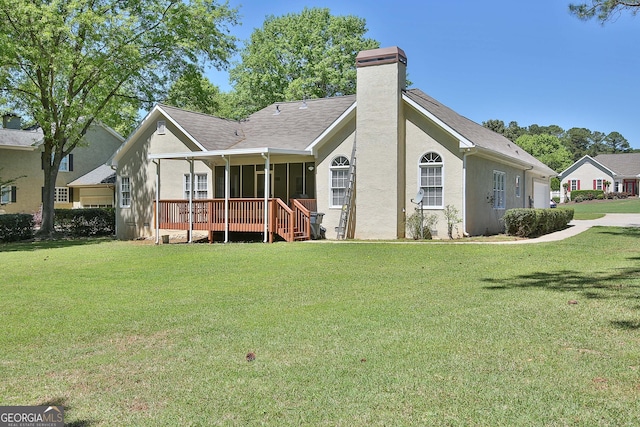 back of property with a wooden deck and a yard