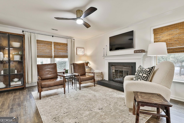 living room with crown molding, ceiling fan, and dark hardwood / wood-style flooring