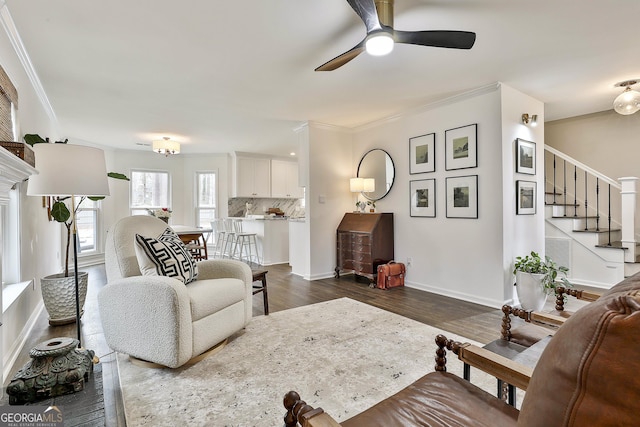 living room with crown molding, ceiling fan, and dark hardwood / wood-style floors