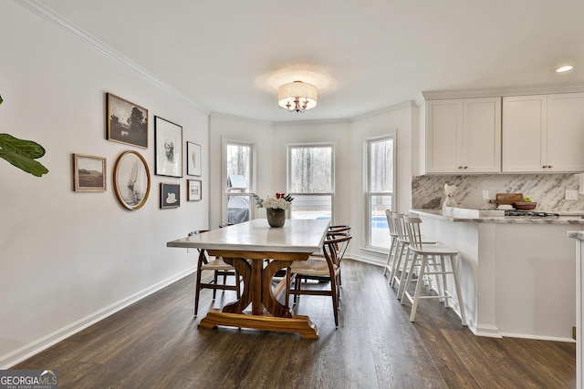 dining space with ornamental molding and dark hardwood / wood-style floors