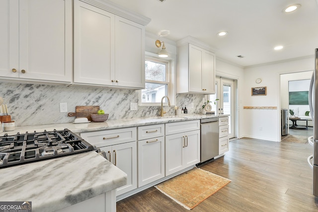 kitchen with sink, light stone counters, stainless steel dishwasher, dark hardwood / wood-style floors, and white cabinets