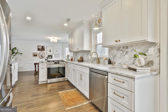 kitchen featuring white cabinetry, appliances with stainless steel finishes, kitchen peninsula, and sink