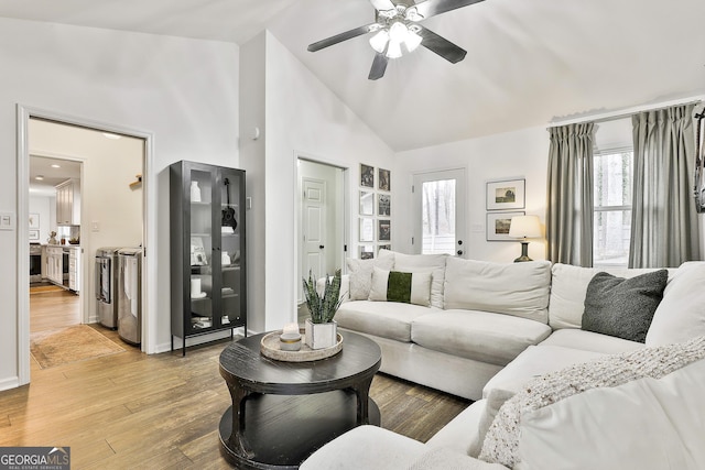 living room featuring ceiling fan, high vaulted ceiling, and light wood-type flooring