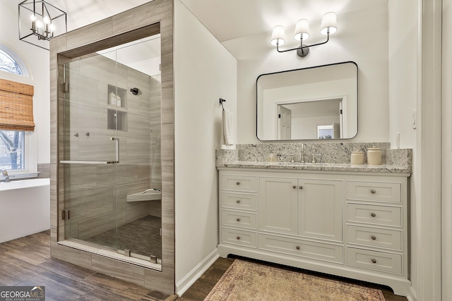 bathroom featuring an inviting chandelier, vanity, separate shower and tub, and wood-type flooring