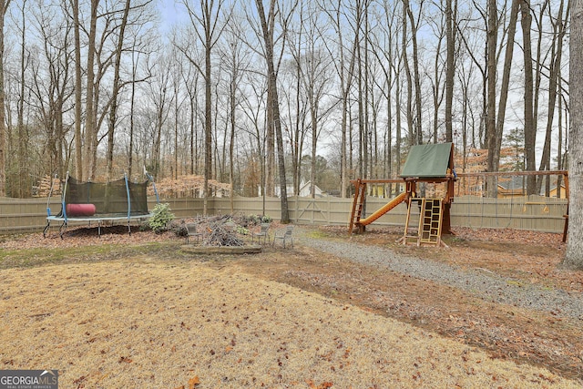 view of yard featuring a playground and a trampoline