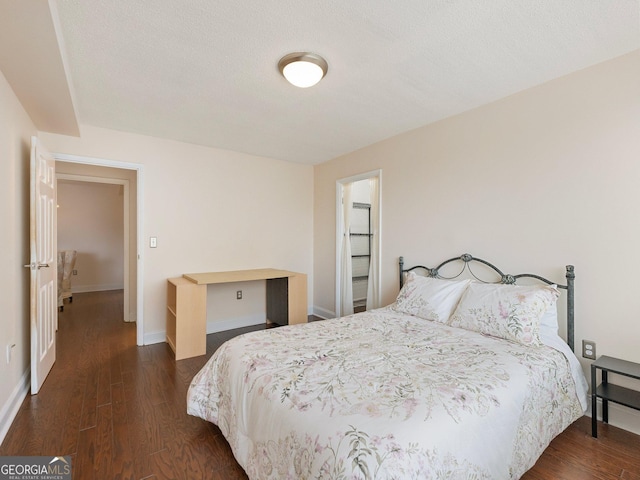 bedroom featuring dark wood-type flooring and a textured ceiling