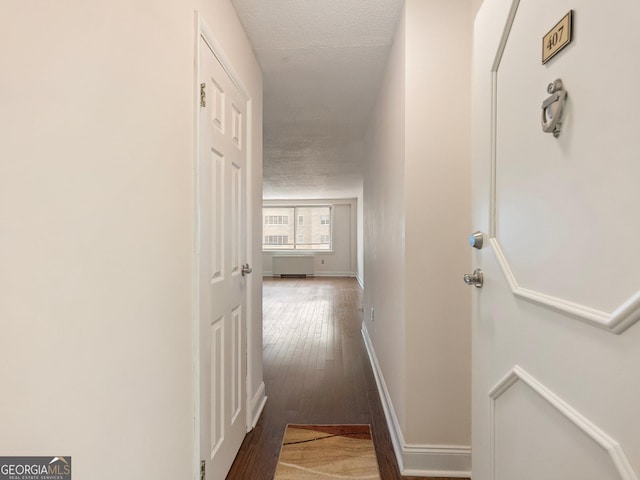 corridor with dark hardwood / wood-style flooring