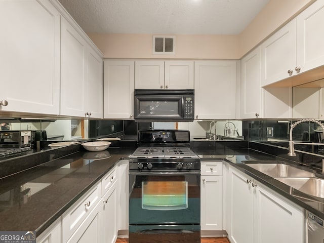 kitchen featuring sink, dark stone countertops, black appliances, a textured ceiling, and white cabinets