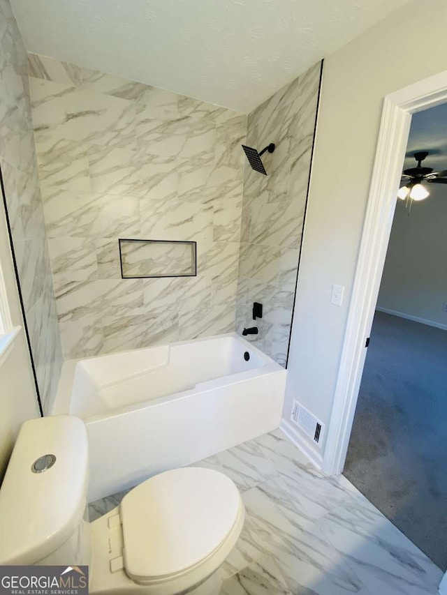 bathroom with tiled shower / bath and toilet