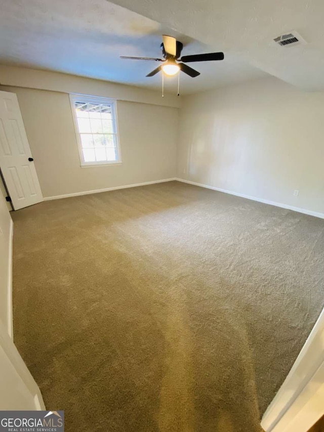 carpeted spare room with ceiling fan