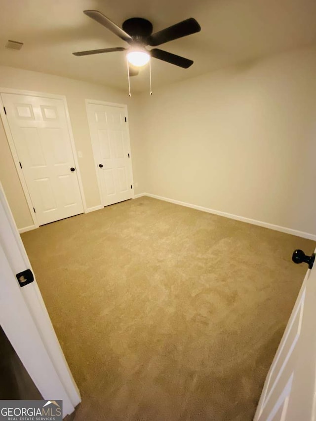 unfurnished bedroom with ceiling fan and carpet