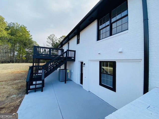 view of side of property with central AC and a deck