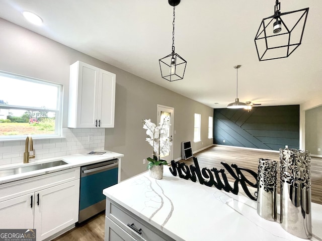 kitchen with pendant lighting, stainless steel dishwasher, sink, and white cabinets