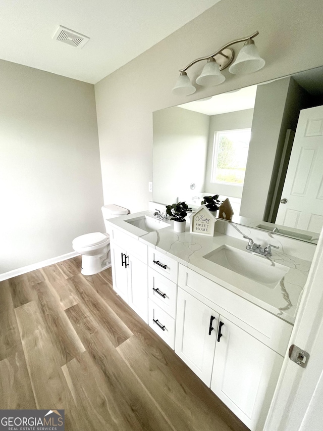 bathroom featuring vanity, toilet, and hardwood / wood-style floors