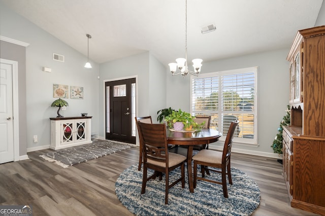 dining room with lofted ceiling, dark hardwood / wood-style floors, and an inviting chandelier