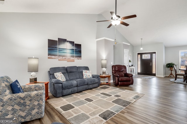 living room with hardwood / wood-style flooring, ceiling fan, and high vaulted ceiling