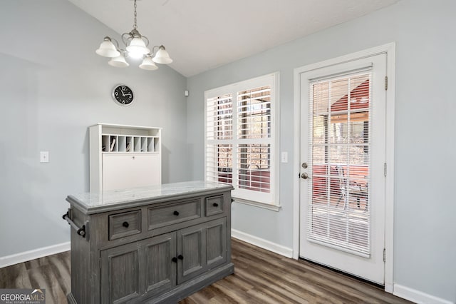 doorway to outside featuring dark hardwood / wood-style flooring, lofted ceiling, and an inviting chandelier