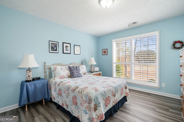 bedroom featuring dark hardwood / wood-style floors and a textured ceiling