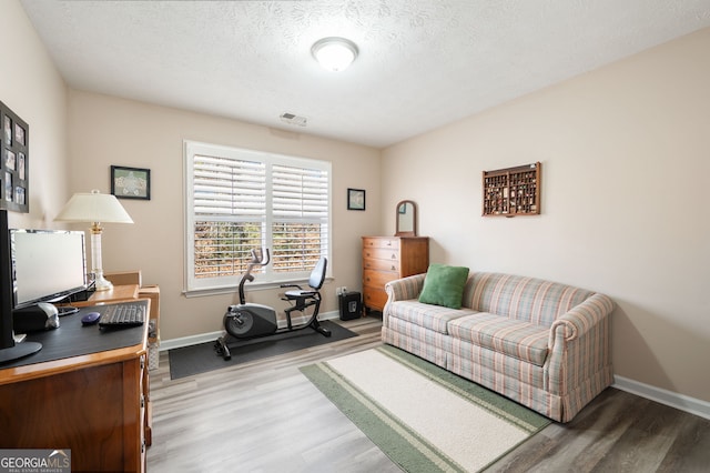 office with hardwood / wood-style floors and a textured ceiling