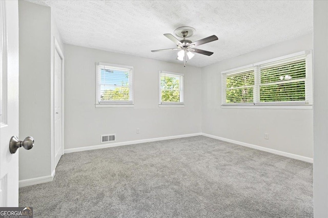 carpeted empty room with ceiling fan and a textured ceiling