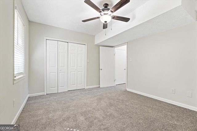 unfurnished bedroom with ceiling fan, carpet floors, and a closet