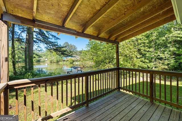 deck with a water view and a yard