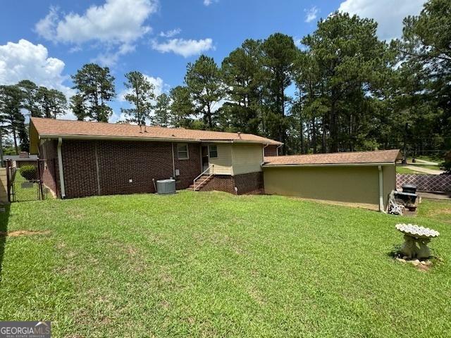 rear view of house featuring a yard