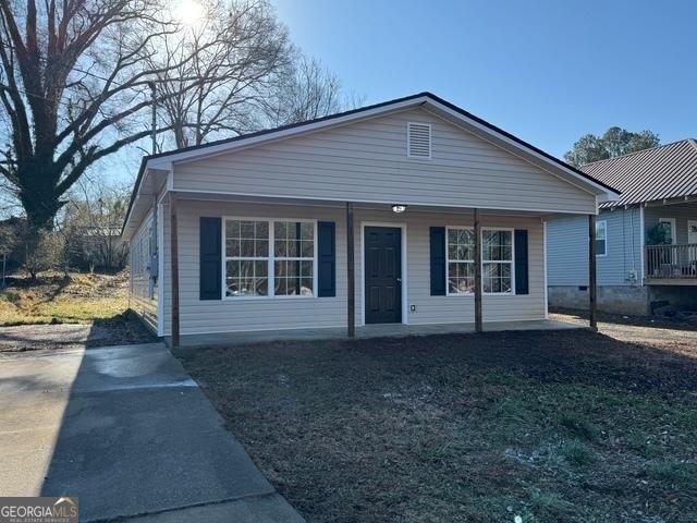 view of front of property with a porch and a front lawn