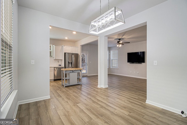 unfurnished living room with light wood-type flooring and ceiling fan