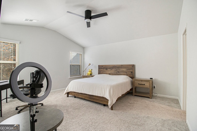 carpeted bedroom featuring multiple windows, vaulted ceiling, and ceiling fan